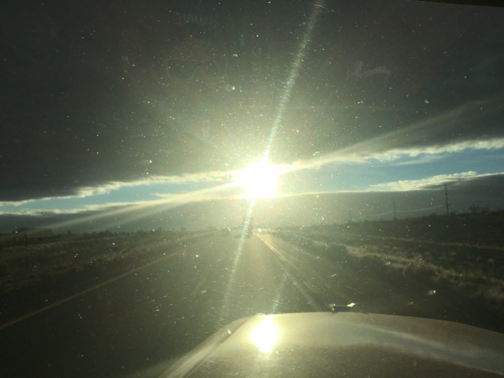 Sunny road view through car windshield.