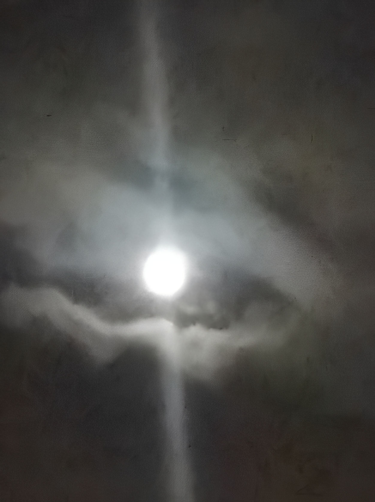 Bright moon surrounded by clouds at night.