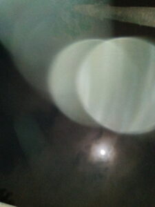 Blurry lights and moon in night sky.