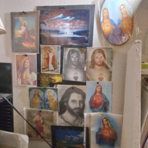 Religious artwork collage on a wall.