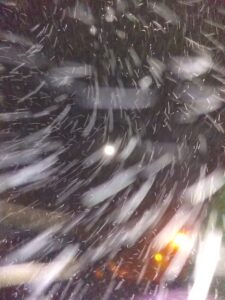 Blurry snowstorm at night with lights.