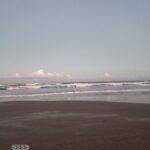 Calm beach with gentle waves and sky.