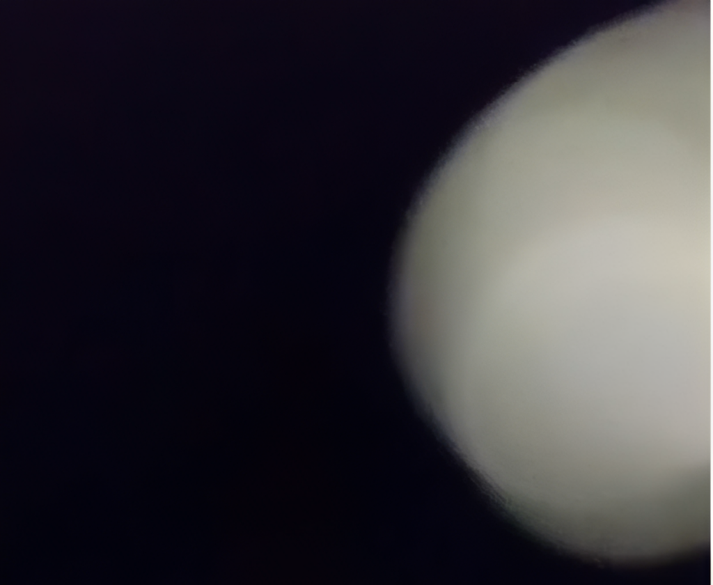 Blurry white object on dark background.