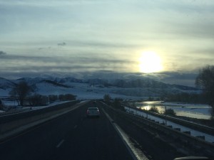 Snowy road with sunset and mountains.