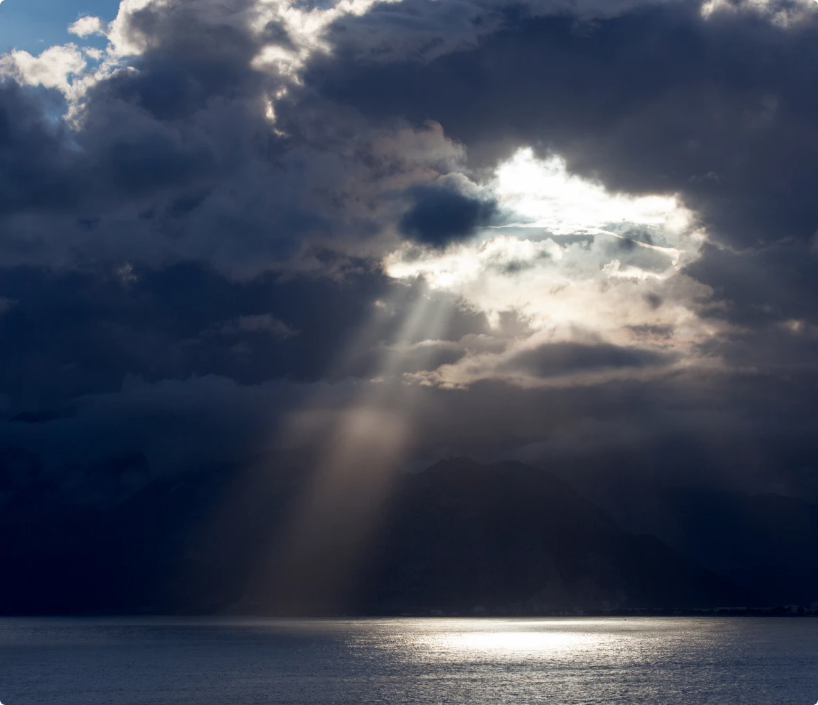 Sun rays breaking through cloudy sky.
