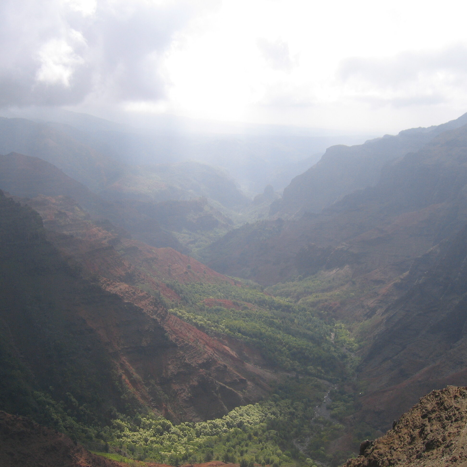Canyon landscape with sunlight and clouds.