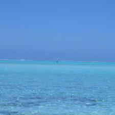 Clear blue ocean under bright blue sky.