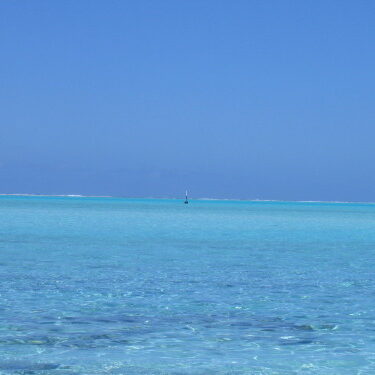 Clear turquoise ocean under bright blue sky.