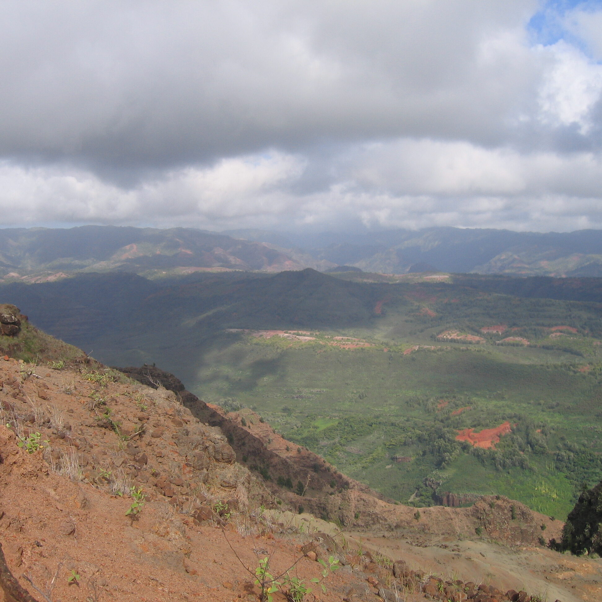 Mountainous landscape with clouds and green valley.