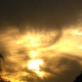 Dramatic sunset with silhouetted trees and clouds.