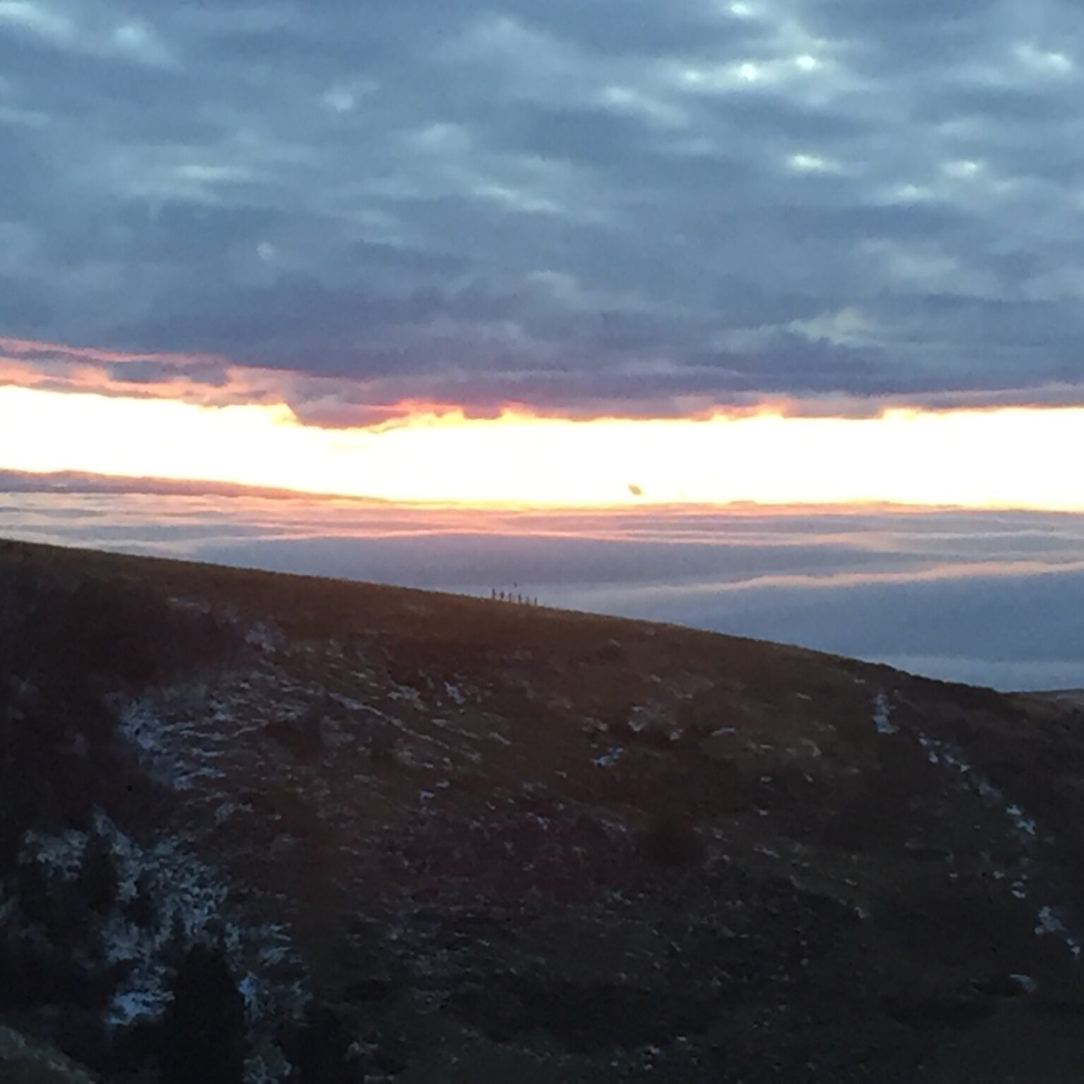 Mountain landscape at sunset with cloudy sky.