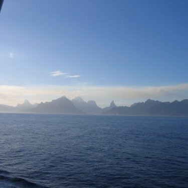 Ocean view with distant mountains at sunrise.