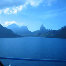 Mountainous landscape with lake under blue sky.