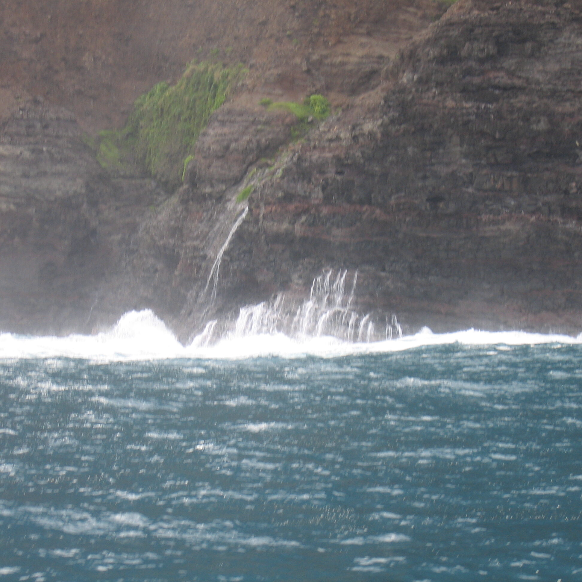 Water splashing against rocky coastal cliff.