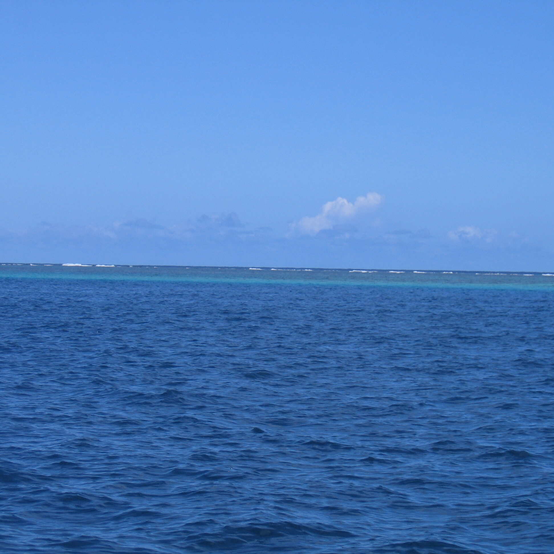 Blue ocean under clear sky horizon.