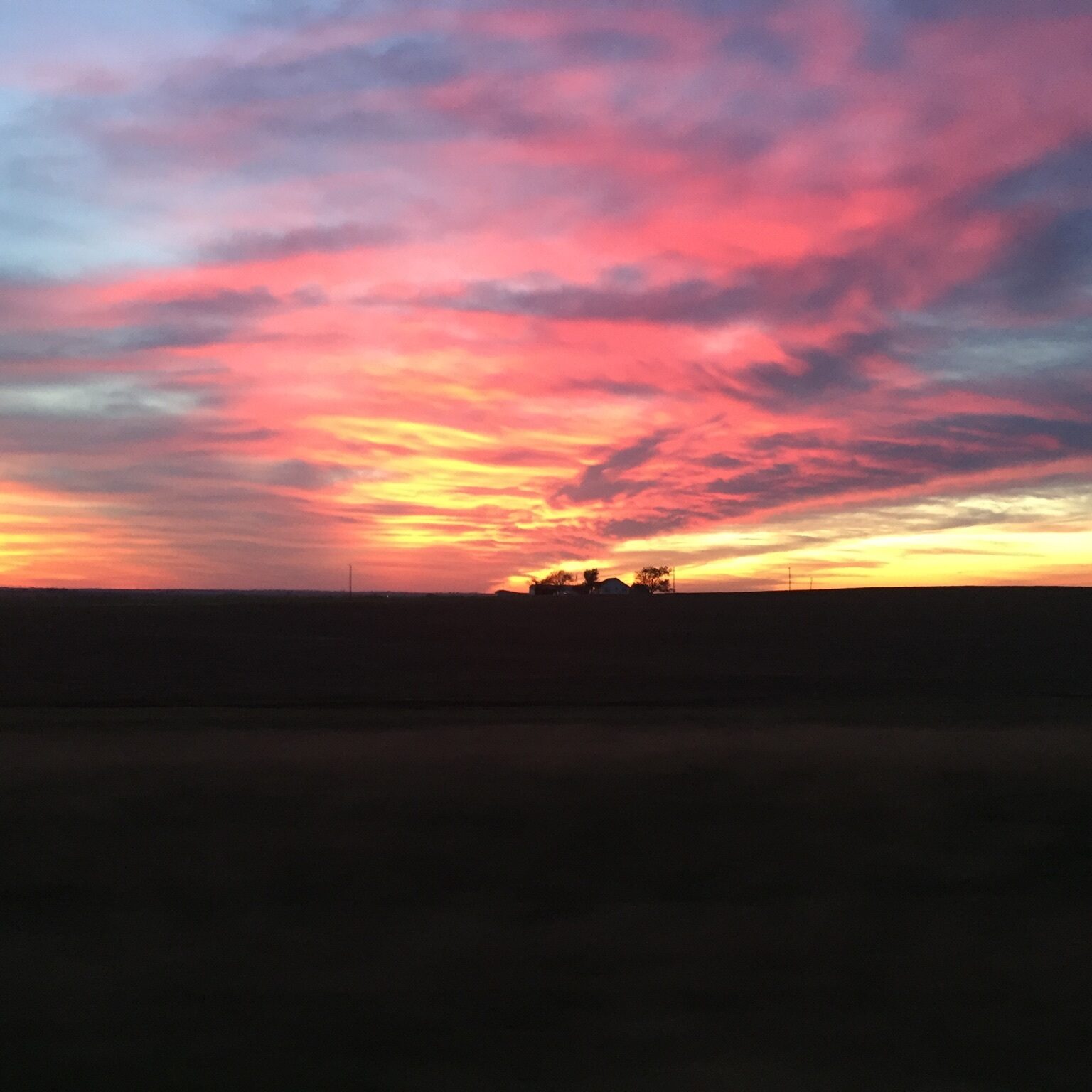 Vibrant sunset over a silhouetted landscape.