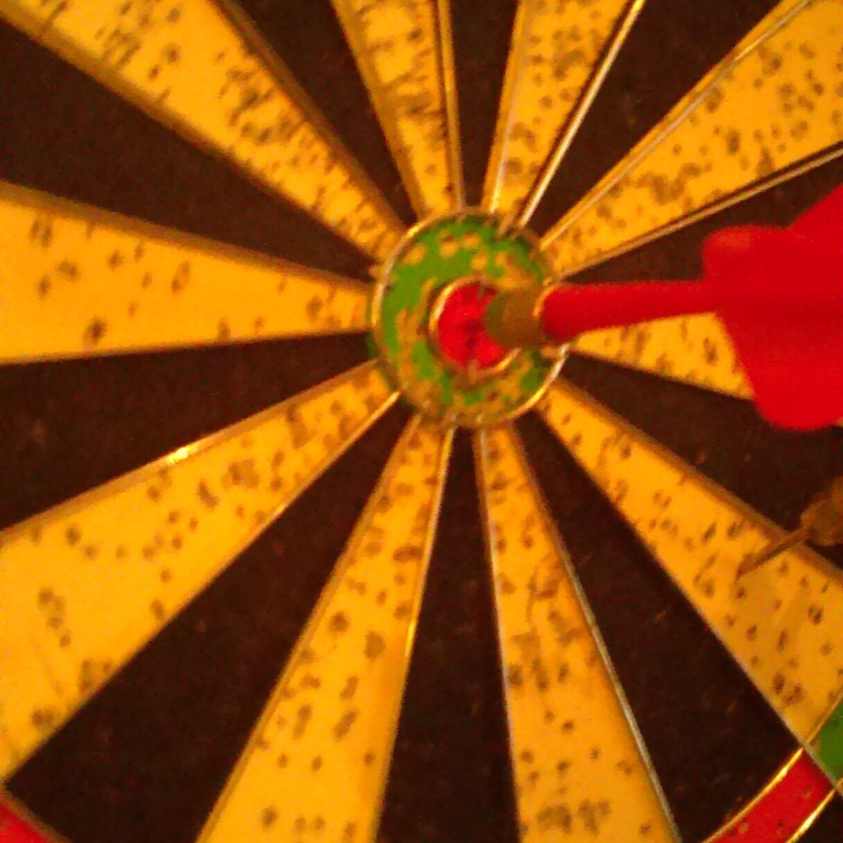 Dartboard with dart hitting the bullseye.