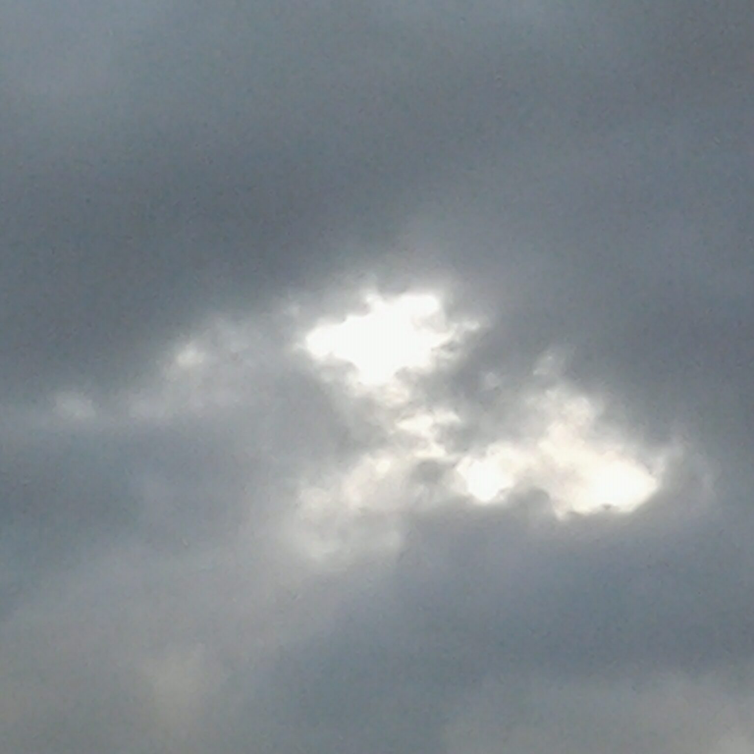 Cloudy sky with sunlight peeking through.