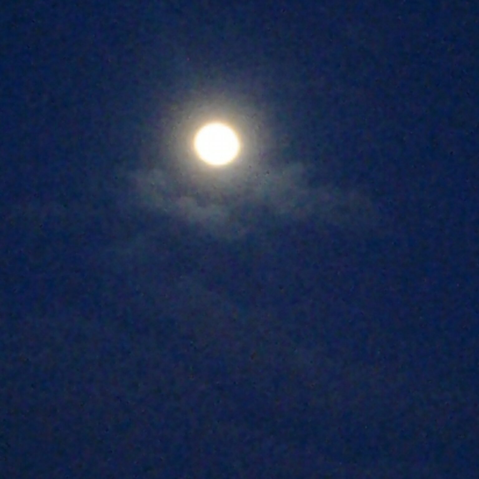 Bright moon in a dark night sky.