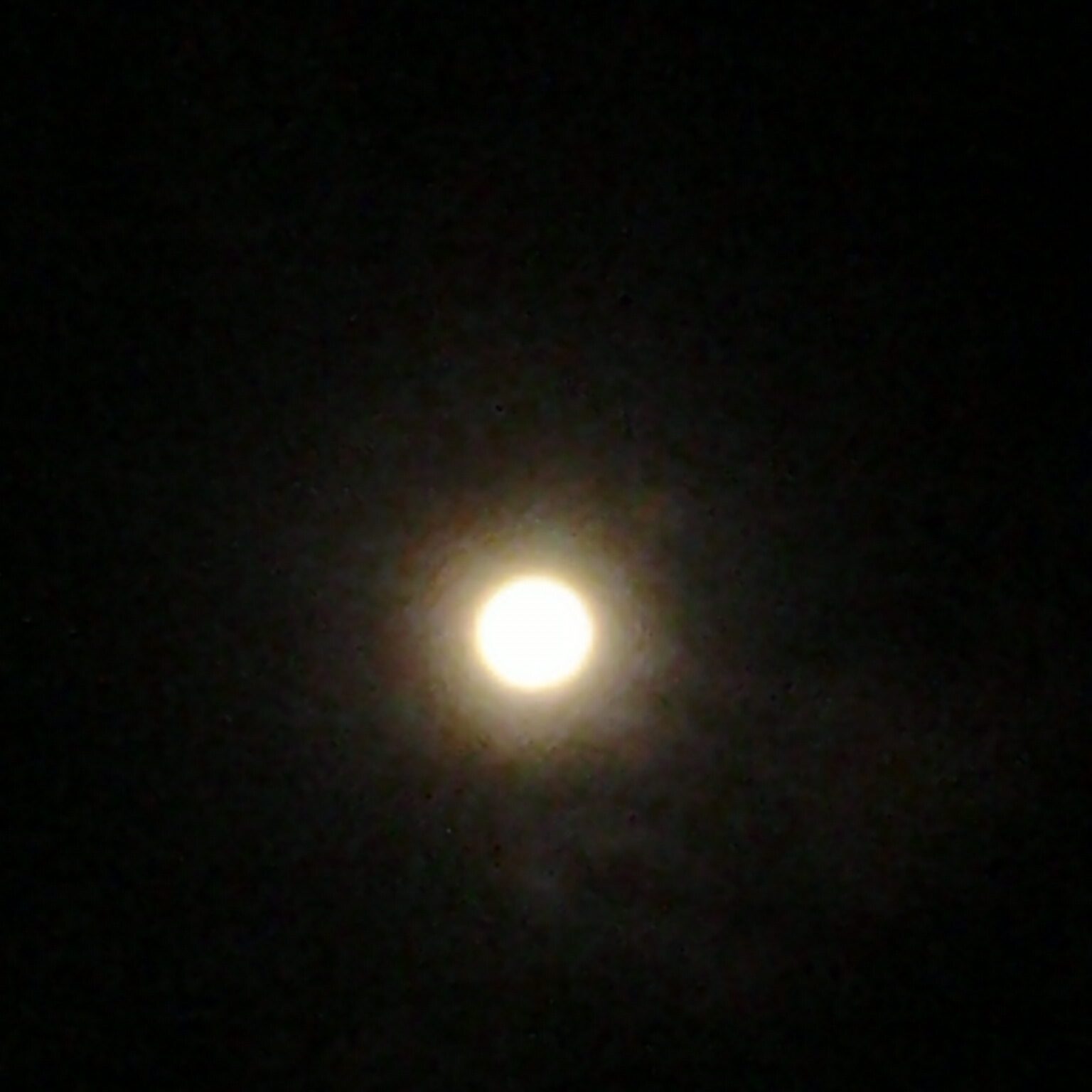 Bright full moon in a dark sky.