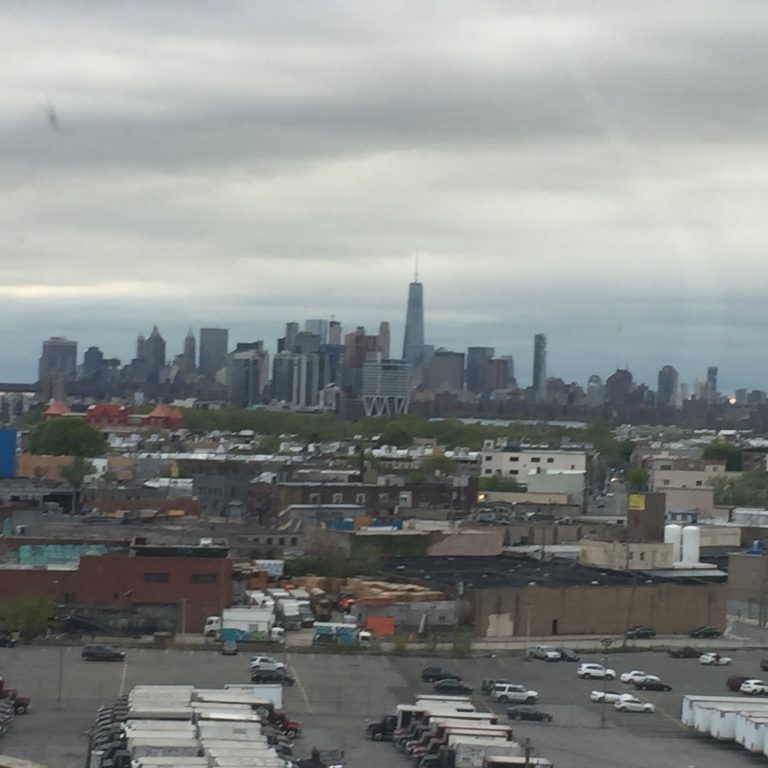 City skyline under cloudy sky, industrial foreground.