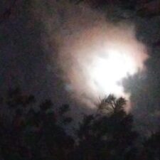 Cloudy night sky with bright moon.
