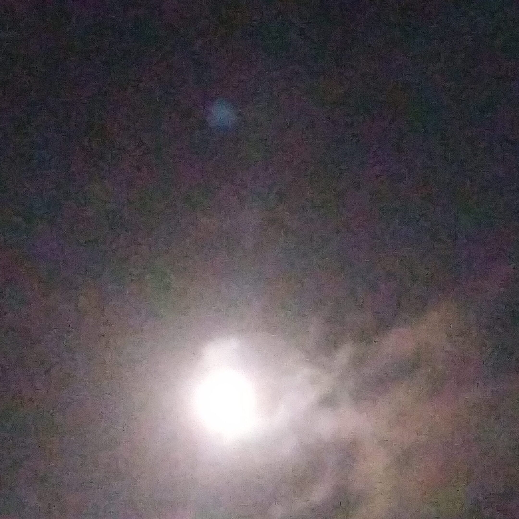 Bright moon in a cloudy night sky.