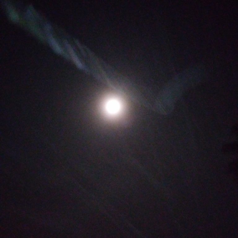 Blurry night sky with bright moon.