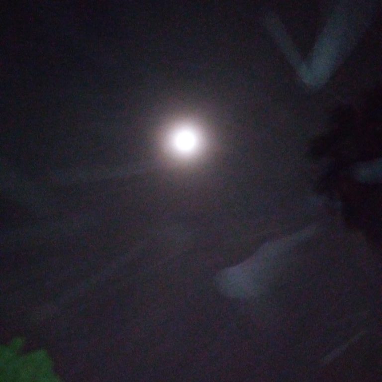 Bright moon in a cloudy night sky.
