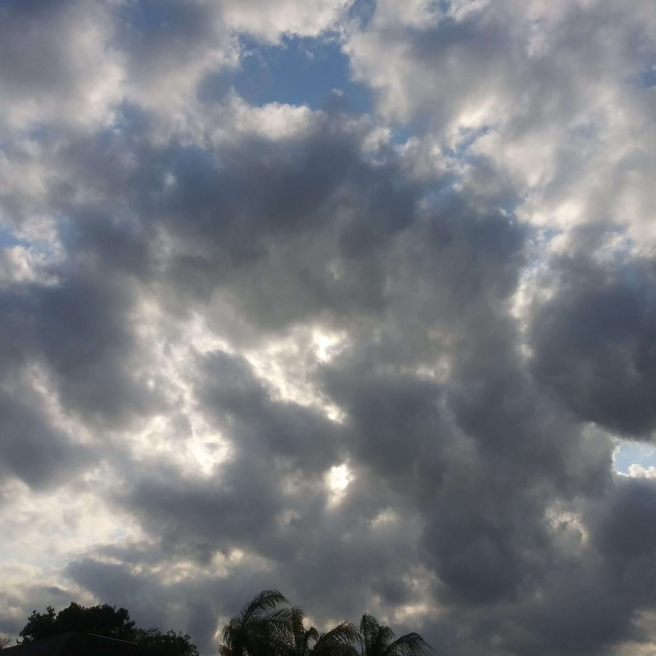 Cloudy sky with scattered sunlight patches.