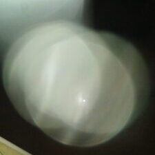 Blurry light orb in dark sky.