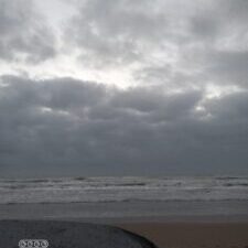 Cloudy beach with overcast sky.