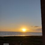 Sunset over the ocean, clear sky.