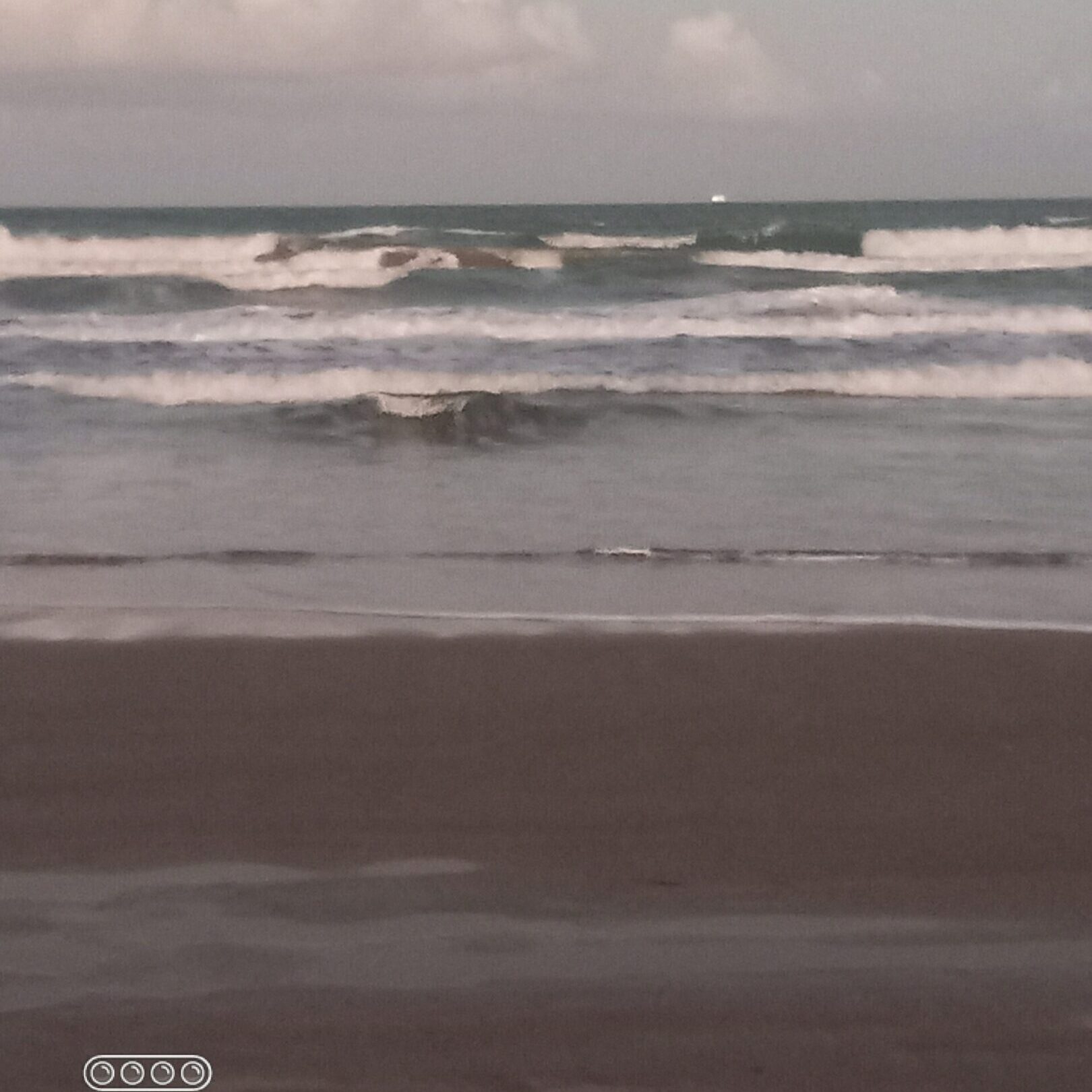 Waves crashing on a sandy beach.