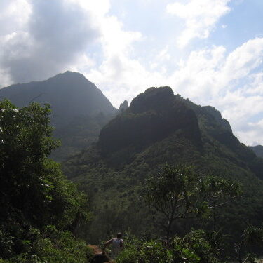 Mountain landscape with lush greenery and clouds.
