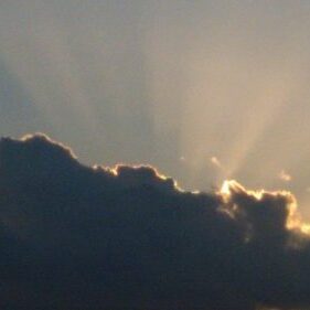 Sun rays shining through dark clouds.