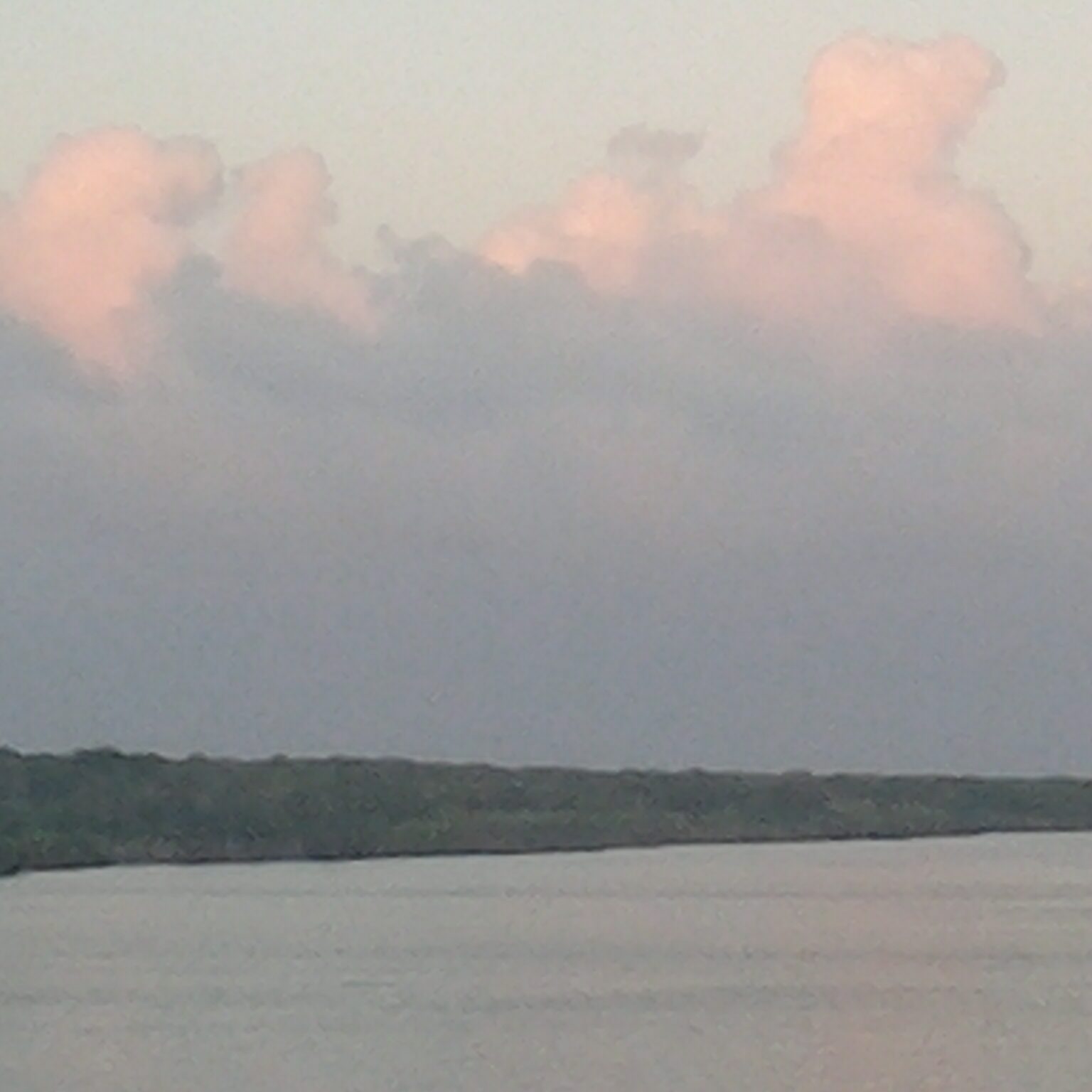 Calm river with pink clouds above.
