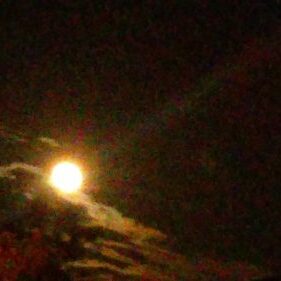 Bright moon in a cloudy night sky.