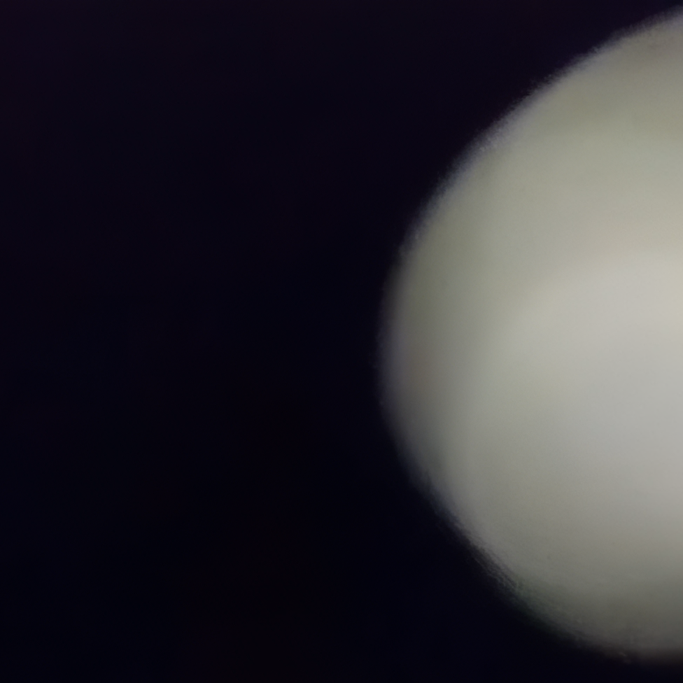Blurry white object on dark background.