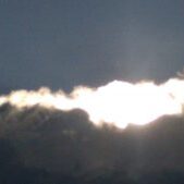 Sunlight breaking through dark cloudy sky.