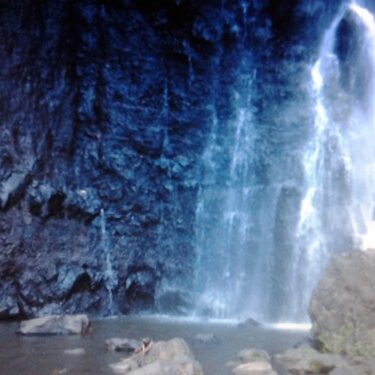 Waterfall cascading over dark rock face.