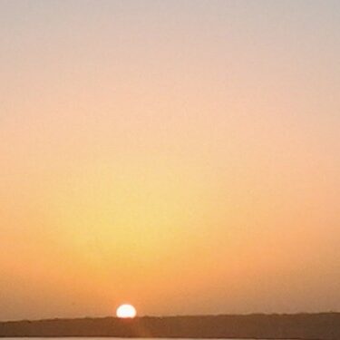 Sunset over a calm, distant horizon.