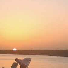 Sunset over calm water and horizon.