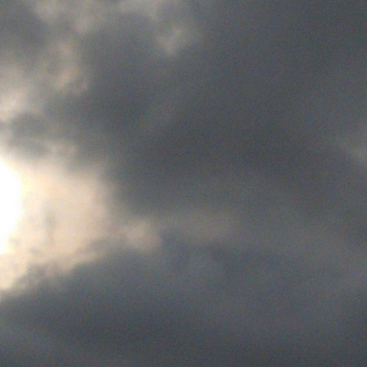 Cloudy sky with sun partially visible.