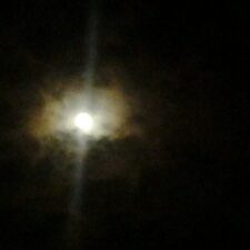 Bright moon surrounded by dark night clouds.