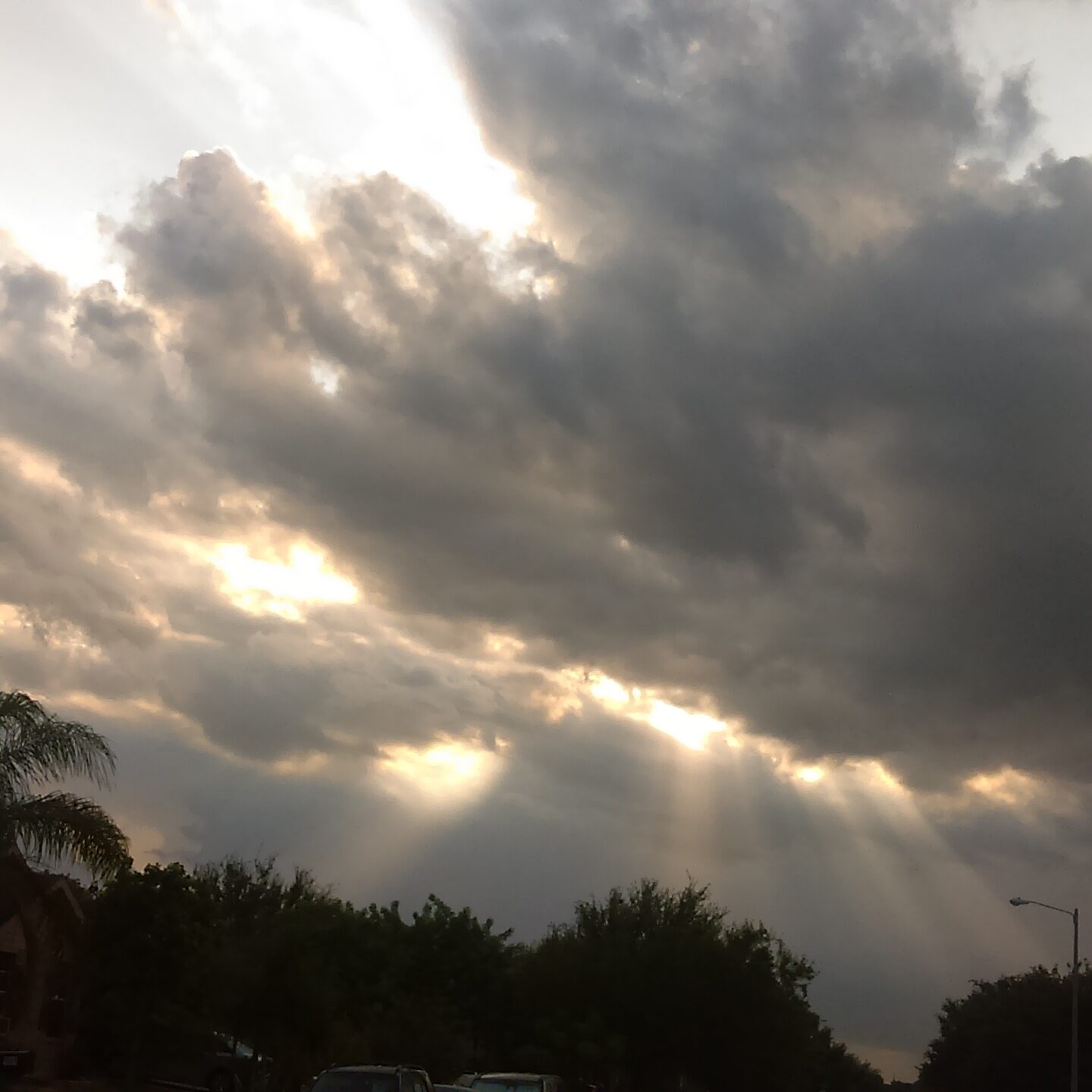 Cloudy sky with sun rays shining through.