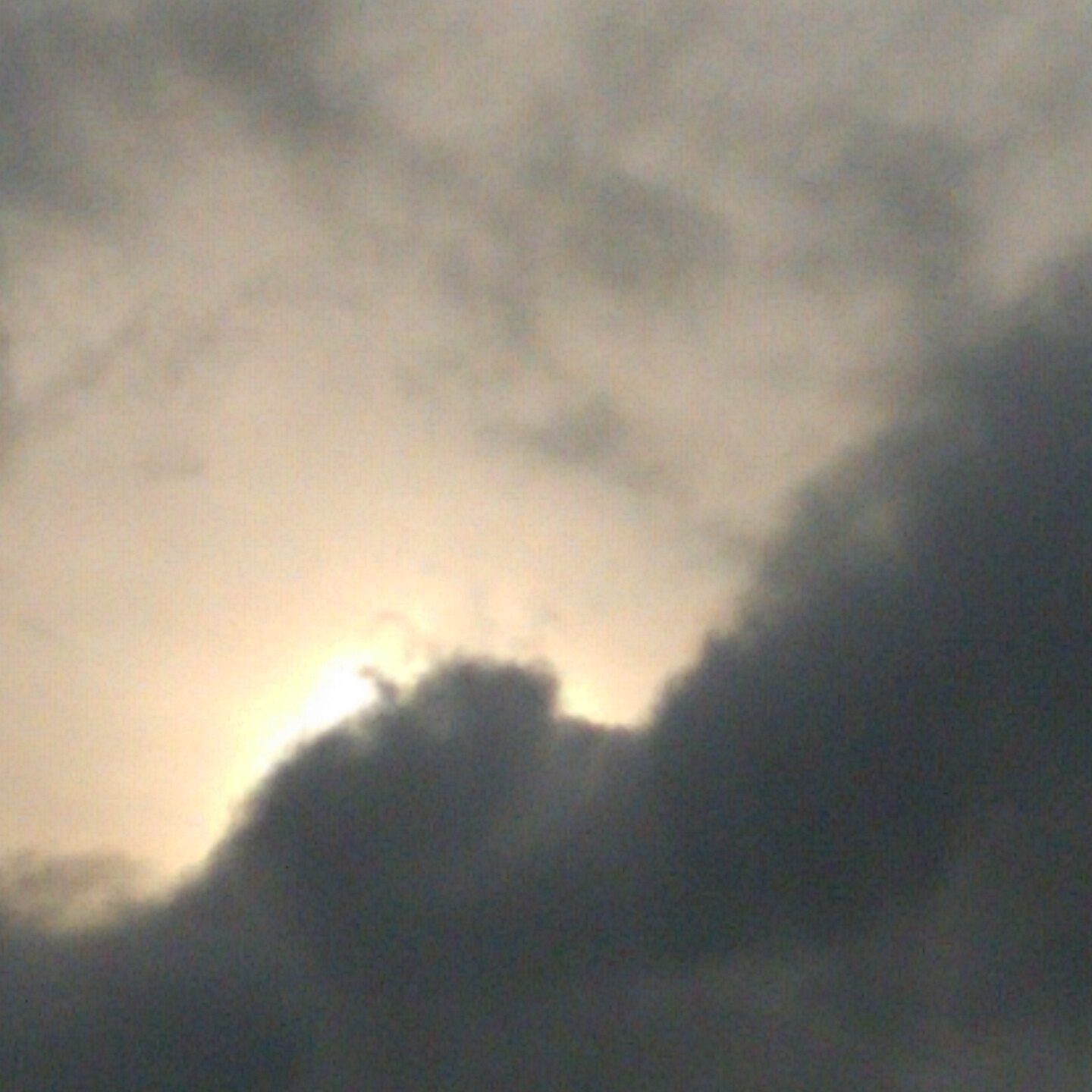 Cloudy sky with sunlight peeking through.