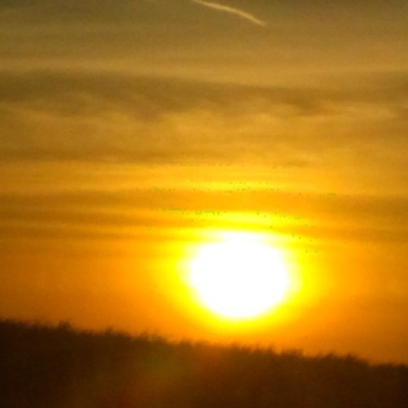 Sunset over horizon with golden sky.