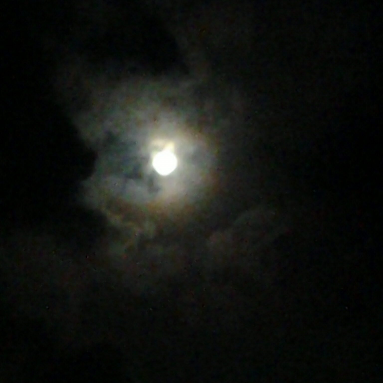 Cloudy night sky with a glowing moon.