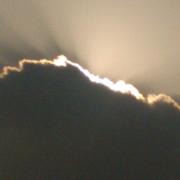Sunlight shining behind a dark cloud.